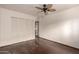 Cozy bedroom with hardwood floors, closet, and a view into the adjacent room at 7719 W Bluefield Ave, Glendale, AZ 85308