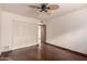 Bedroom featuring hardwood floors, a ceiling fan, and a double closet with folding doors at 7719 W Bluefield Ave, Glendale, AZ 85308