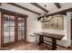 Eat-in kitchen area with tile mural, wooden table, and access to an outdoor patio at 7719 W Bluefield Ave, Glendale, AZ 85308