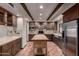 Bright kitchen with stainless steel appliances, custom cabinets, butcher block island, and terra cotta tile flooring at 7719 W Bluefield Ave, Glendale, AZ 85308