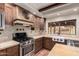 Well-equipped kitchen with stainless steel appliances, custom cabinets, gas range, and farmhouse sink at 7719 W Bluefield Ave, Glendale, AZ 85308