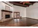 Spacious living room features a stone fireplace, wood floors, exposed beams, and glass doors at 7719 W Bluefield Ave, Glendale, AZ 85308