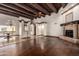 Open living room features wood floors, wooden beam ceiling, a stone fireplace, and lots of light at 7719 W Bluefield Ave, Glendale, AZ 85308