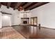 Bright and spacious living room with wood floors, exposed beams, fireplace, and french doors at 7719 W Bluefield Ave, Glendale, AZ 85308