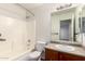 Well-lit bathroom with a shower-tub combo, neutral tile surround, and vanity sink at 8527 E Lindner Ave, Mesa, AZ 85209