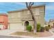 Two-story home with tan stucco, two car garage, covered front porch, and bare tree in the front yard at 8527 E Lindner Ave, Mesa, AZ 85209