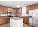 Modern kitchen with wood cabinets, stainless steel appliances, island, and mosaic backsplash at 8527 E Lindner Ave, Mesa, AZ 85209