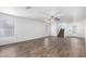 Large, open living room with wood-look floors, ceiling fan, staircase, and natural light from large window at 8527 E Lindner Ave, Mesa, AZ 85209