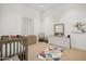 Light-filled Bedroom with a crib, changing station, and colorful rug at 8832 E Wethersfield Rd, Scottsdale, AZ 85260