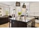 Well-designed kitchen island with a marble countertop with seating that flows into the dining space at 8832 E Wethersfield Rd, Scottsdale, AZ 85260