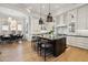 Modern kitchen with white cabinets, stainless appliances, and island seating open to dining at 8832 E Wethersfield Rd, Scottsdale, AZ 85260