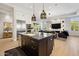 Modern open concept kitchen with stainless appliances, island seating and sight lines to living room at 8832 E Wethersfield Rd, Scottsdale, AZ 85260