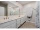 Elegant bathroom with double sinks, gold-tone faucets, and a large mirror over a white vanity at 8924 E Charter Oak Dr, Scottsdale, AZ 85260