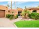 Home featuring lush landscaping, a gated entrance, a terracotta roof, and a three-car garage at 8924 E Charter Oak Dr, Scottsdale, AZ 85260