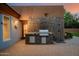 Inviting outdoor kitchen with a built-in grill, stone backsplash, and brick pavers at 8924 E Charter Oak Dr, Scottsdale, AZ 85260