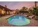 Relaxing pool area with a stone waterfall feature, lush landscaping, and a spacious patio at 8924 E Charter Oak Dr, Scottsdale, AZ 85260