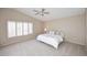 Bright main bedroom featuring plantation shutters, neutral decor, plush carpet, and a ceiling fan at 9012 E Sutton Dr, Scottsdale, AZ 85260