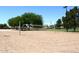 Outdoor sand volleyball court with a net is surrounded by green trees on a sunny day at 9012 E Sutton Dr, Scottsdale, AZ 85260