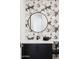 Chic powder room with a floating vanity, modern faucet, a round mirror, and floral wallpapered accent wall at 9280 E Thompson Peak Pkwy # 29, Scottsdale, AZ 85255