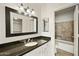 Well-lit bathroom featuring a black granite countertop, framed mirror, and a tiled shower/tub combination at 9450 E Becker Ln # 2090, Scottsdale, AZ 85260