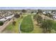 Aerial view of a lush green golf course with a scenic pond, surrounded by homes and distant mountains at 9576 E Fairway Blvd, Sun Lakes, AZ 85248