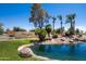 Sun Lakes Country Club entrance featuring lush landscaping, a pond, and a serene waterfall, welcoming residents and guests at 9576 E Fairway Blvd, Sun Lakes, AZ 85248