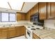 Functional kitchen featuring tile countertops, wood cabinets, and classic appliances at 9576 E Fairway Blvd, Sun Lakes, AZ 85248