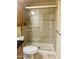 Close-up of the shower that features a shower head, sliding glass door and light brown tile walls at 1001 W 17Th St, Tempe, AZ 85281