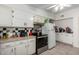 Traditional kitchen with tile floor, stainless steel appliances, and white cabinets at 10716 W Peoria Ave, Sun City, AZ 85351