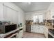 Traditional kitchen with tile floor, stainless steel appliances, and white cabinets at 10716 W Peoria Ave, Sun City, AZ 85351