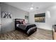 Bedroom with natural light, wood floors, ceiling fan, and two decor art pieces at 10800 E Cactus Rd # 7, Scottsdale, AZ 85259