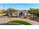 Beautiful front exterior with a circular driveway, lush landscaping, and a well-maintained lawn at 10800 E Cactus Rd # 7, Scottsdale, AZ 85259