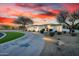 Stunning home exterior at sunset, featuring desert landscaping, a circular driveway, and warm lighting at 10800 E Cactus Rd # 7, Scottsdale, AZ 85259