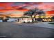 Exterior home view at sunset with desert landscape, circular driveway, and inviting front entrance at 10800 E Cactus Rd # 7, Scottsdale, AZ 85259