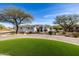 Beautiful home exterior featuring a circular driveway, lush lawn, and well-maintained landscaping at 10800 E Cactus Rd # 7, Scottsdale, AZ 85259