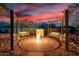 Outdoor fire pit area with four porch swings and desert landscaping at 10800 E Cactus Rd # 7, Scottsdale, AZ 85259