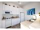 Cozy kitchen features white cabinets, appliances, tile countertops, and hardwood floors at 10800 E Cactus Rd # 7, Scottsdale, AZ 85259