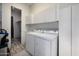 Bright laundry room with washer, dryer, storage cabinets, and hardwood floors at 10800 E Cactus Rd # 7, Scottsdale, AZ 85259