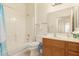 Bright bathroom with shower-tub combo and oak vanity offering practical storage solutions at 10960 E Monte Ave # 164, Mesa, AZ 85209