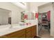 This bathroom features double sinks, oak cabinets, a walk-in closet and seamless access to the bedroom at 10960 E Monte Ave # 164, Mesa, AZ 85209