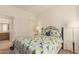 Cozy bedroom featuring a comfortable bed with colorful quilt and a view into the Primary bathroom at 10960 E Monte Ave # 164, Mesa, AZ 85209