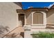 Close-up of the front door, including a neutral stucco exterior and xeriscaping at 10960 E Monte Ave # 164, Mesa, AZ 85209