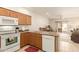 This kitchen has oak cabinets, tile floors, white appliances and opens to the dining and living area at 10960 E Monte Ave # 164, Mesa, AZ 85209