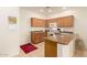 A bright kitchen featuring oak cabinets, a white door, and a red accent rug at 10960 E Monte Ave # 164, Mesa, AZ 85209