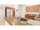 This kitchen features a stainless steel double sink, oak cabinets, and granite countertops at 10960 E Monte Ave # 164, Mesa, AZ 85209