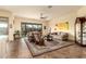 Comfortable living room with tiled floors, ceiling fan, area rug, and sliding glass doors leading to patio at 11351 E Pampa Ave, Mesa, AZ 85212