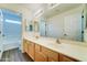 Bathroom boasts a dual sink vanity, wood-look floor, and a view to the tub and toilet room at 1136 E Baylor Ln, Gilbert, AZ 85296