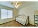 Cozy bedroom with neutral walls, carpet, ceiling fan, and window offering plenty of natural light at 1136 E Baylor Ln, Gilbert, AZ 85296