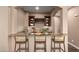 Stylish bar area featuring granite countertops, dark wood cabinets, and seating for three at 12957 W Hummingbird Ter, Peoria, AZ 85383