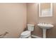 This is a half-bathroom featuring a pedestal sink, toilet, and a neutral color scheme at 12957 W Hummingbird Ter, Peoria, AZ 85383